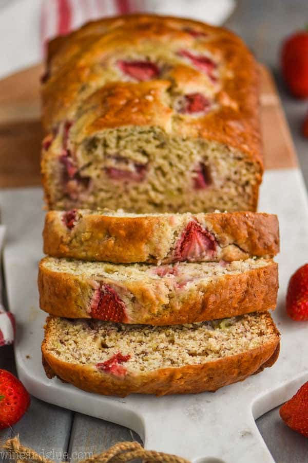 overhead view of strawberry banana bread sliced on a marble cutting board
