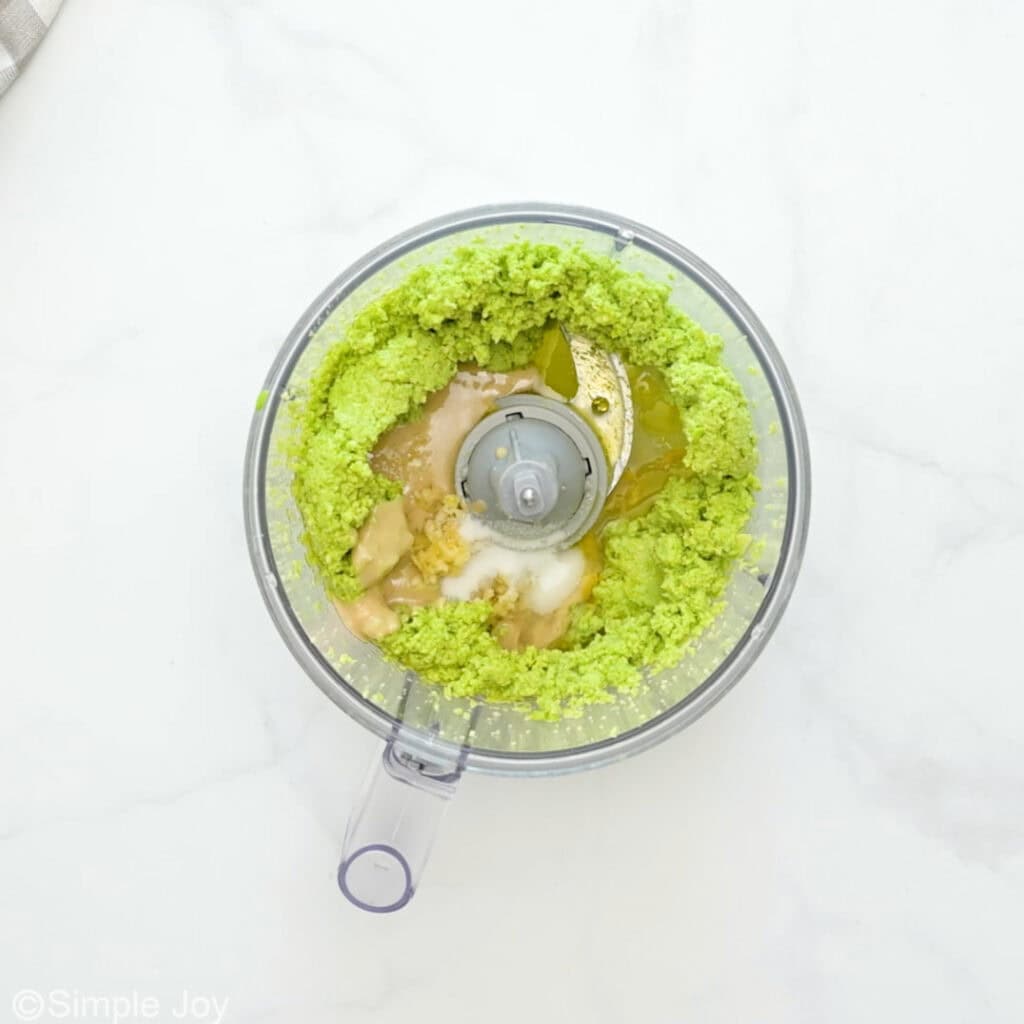 overhead of blended edamame, lemon juice, olive oil, garlic, and salt in a food processor to make edamame hummus