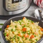 black bowl filled with instant pot chicken and rice casserole in front of an instant pot