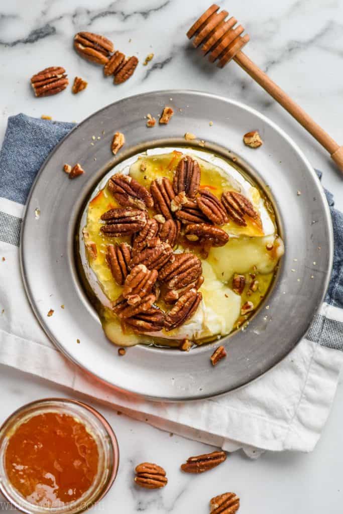 overhead view of baked brie recipe on a silver plate