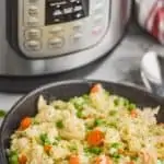 black bowl filled with instant pot chicken and rice casserole in front of an instant pot
