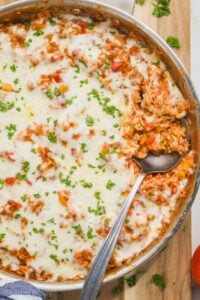 overhead of a skillet of stuffed pepper casserole with a spoon digging in