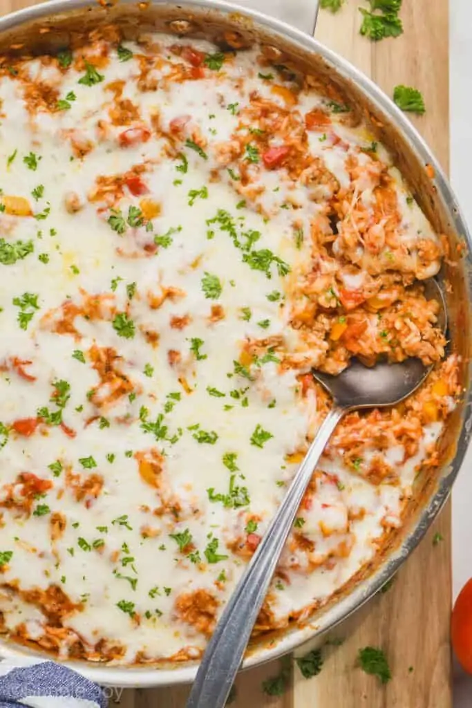 overhead of a skillet of stuffed pepper casserole with a spoon digging in 