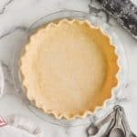 a pie crust recipe that has been transferred to a glass pie pan and the rim of it has been pinched - 31
