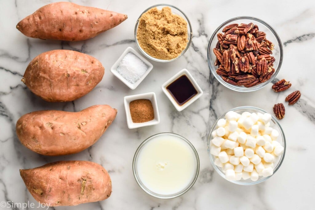 sweet potatoes, brown sugar, salt, nutmeg, vanilla, milk, marshmallows and pecans on a. counter top - ingredients for sweet potato casserole