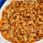 sweet potato casserole with pecans in a white casserole dish on a wire rack with a blue towel in the background