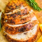 turkey breast that has been cooked and is cut up sitting on a cutting board with orange slices and rosemary sprigs - 21