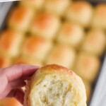 pinterest graphic of hand holding a roll with pan in back ground, says: "one hour dinner rolls, simplejoy.com"