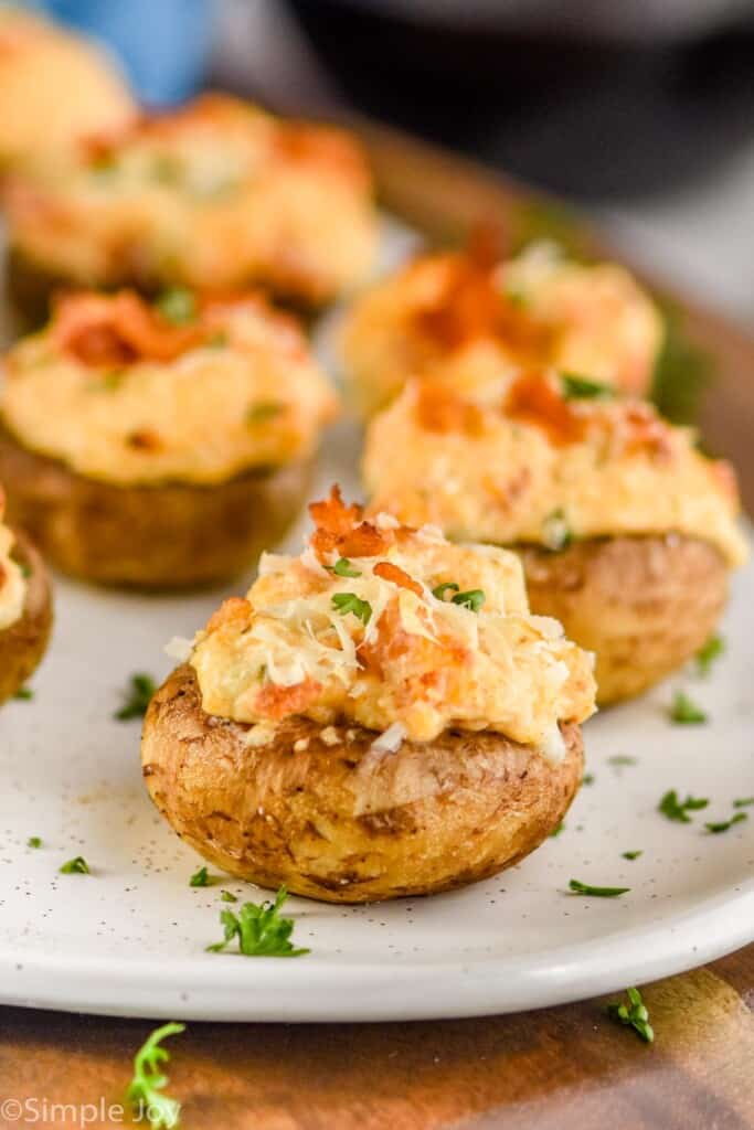 close up of cream cheese stuffed mushrooms on a platter