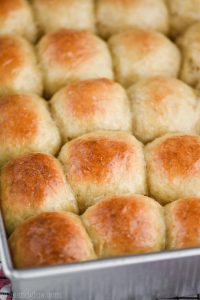 side view of a pan full of a dinner roll recipe, baked and golden brown on the top