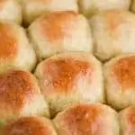 side view of a pan full of a dinner roll recipe, baked and golden brown on the top