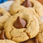 a close up photo of a peanut butter blossom - crisp peanut butter cookie with a Hershey kiss buried into the top - 31