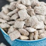 a blue detailed bowl against a dark surface overflowing with a puppy chow recipe - 13