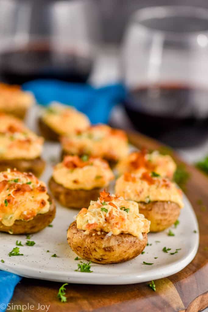 stuffed mushroom caps on a platter with wine in the background