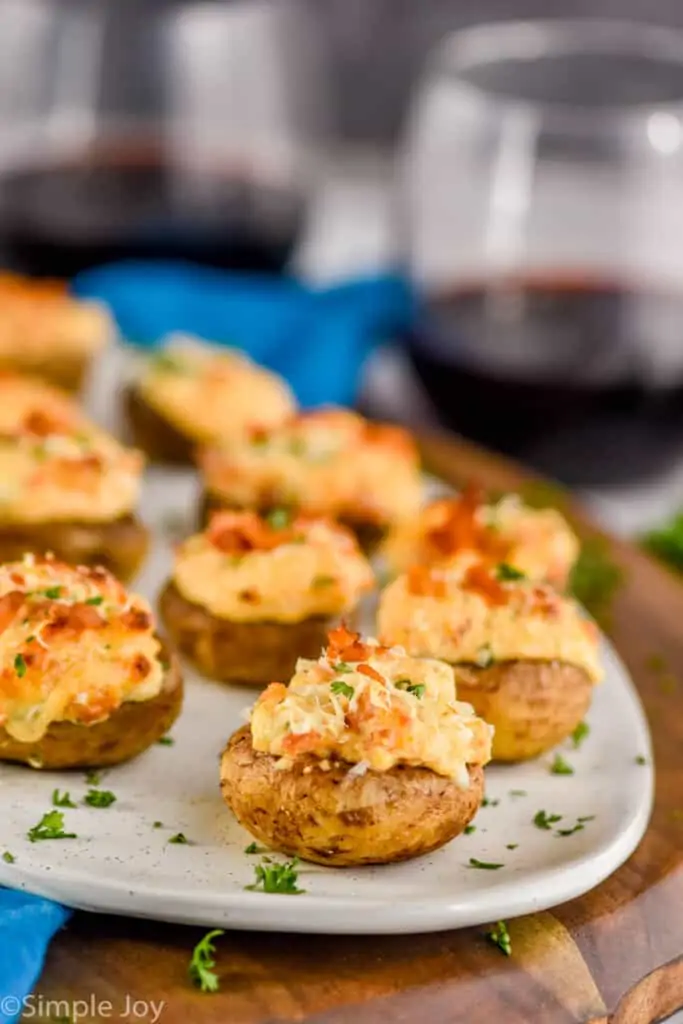 stuffed mushroom caps on a platter with wine in the background