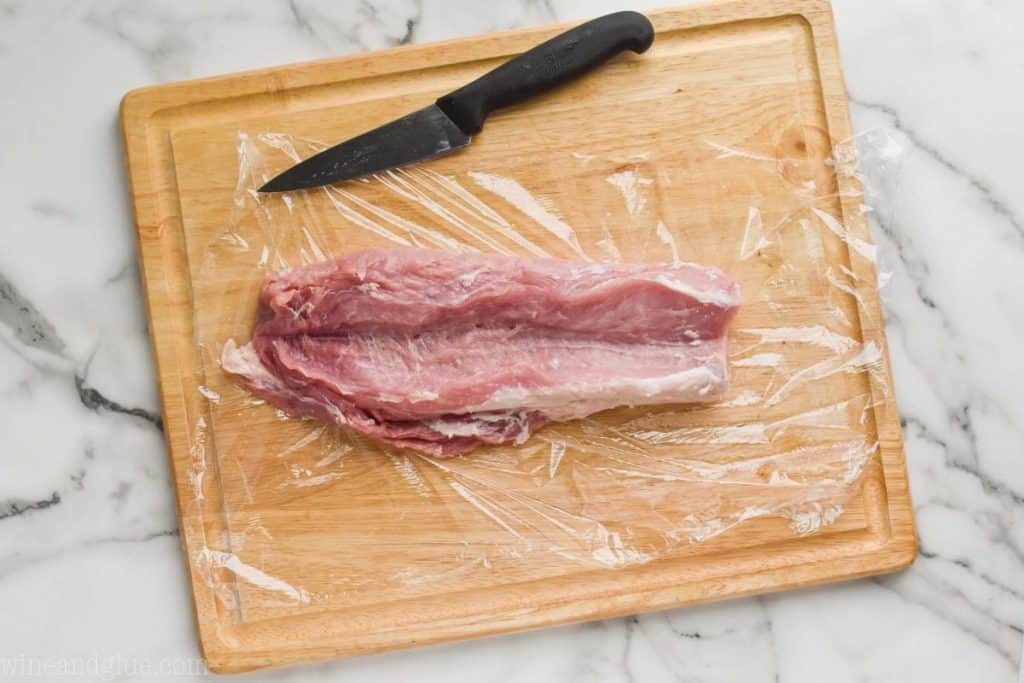 a pork tenderloin that has been butterflied open on a cutting board