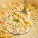 Pinterest graphic of ladle spooning up creamy chicken noodle soup