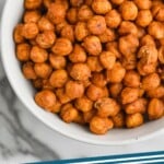 pinterest graphic of overhead view of a white bowl on a marble countertop full of roasted chickpeas, says: "roasted chickpeas simplejoy.com"