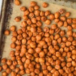 overhead view of roasted chickpeas on a vintage tray that is lined with parchment paper