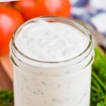 pinterest graphic of small mason jar of homemade ranch dressing on a cutting board next to fresh dill with tomatoes in the background, says: "the best ranch dressing, simplejoy.com"