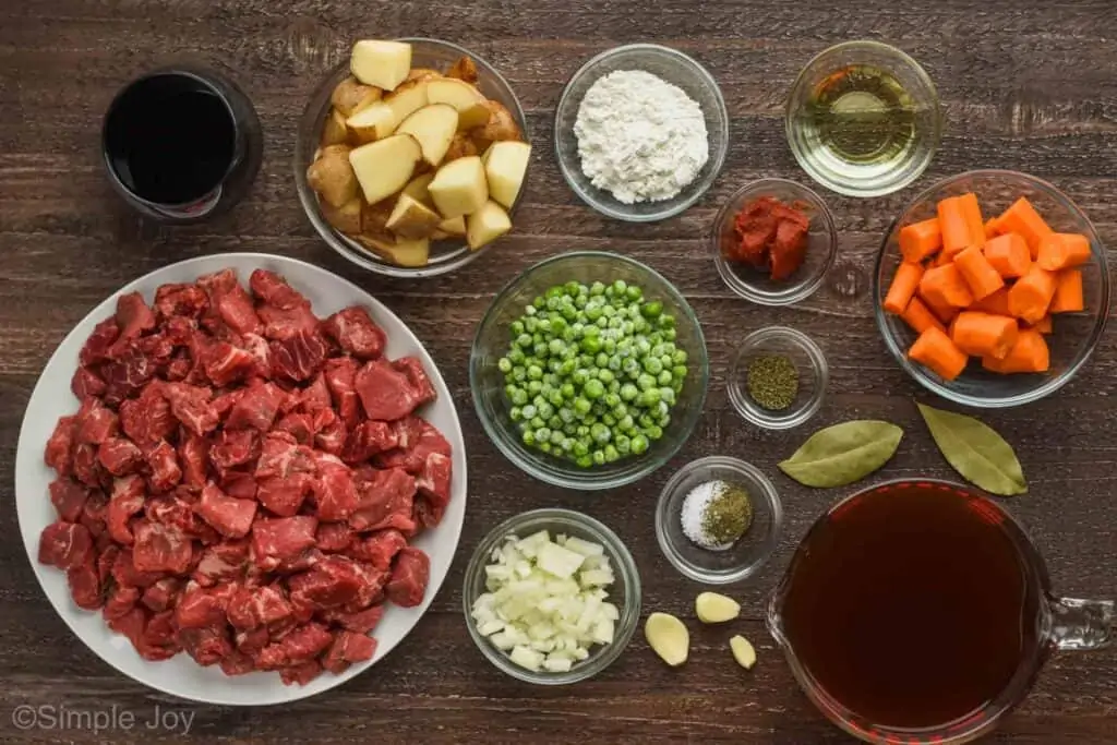 overhead view of small plates and bowls holding all of the ingredients for beef stew