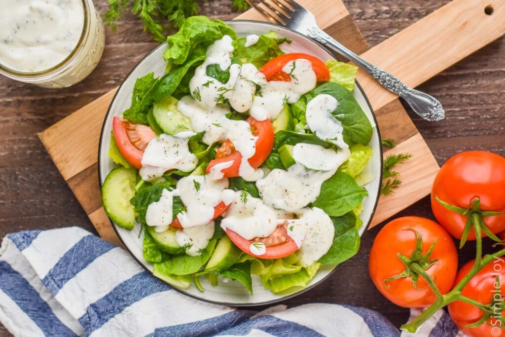 overhead view of a salad on a plate on a cutting board topped with ranch dressing recipe