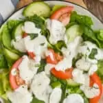 overhead view of a salad on a plate on a cutting board topped with ranch dressing recipe