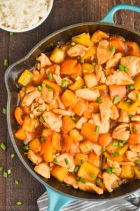 close up overhead overhead Hawaiian chicken recipe in a skillet garnished with green onions