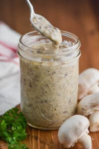 a spoonful of homemade condensed cream of mushroom soup dripping into the jar