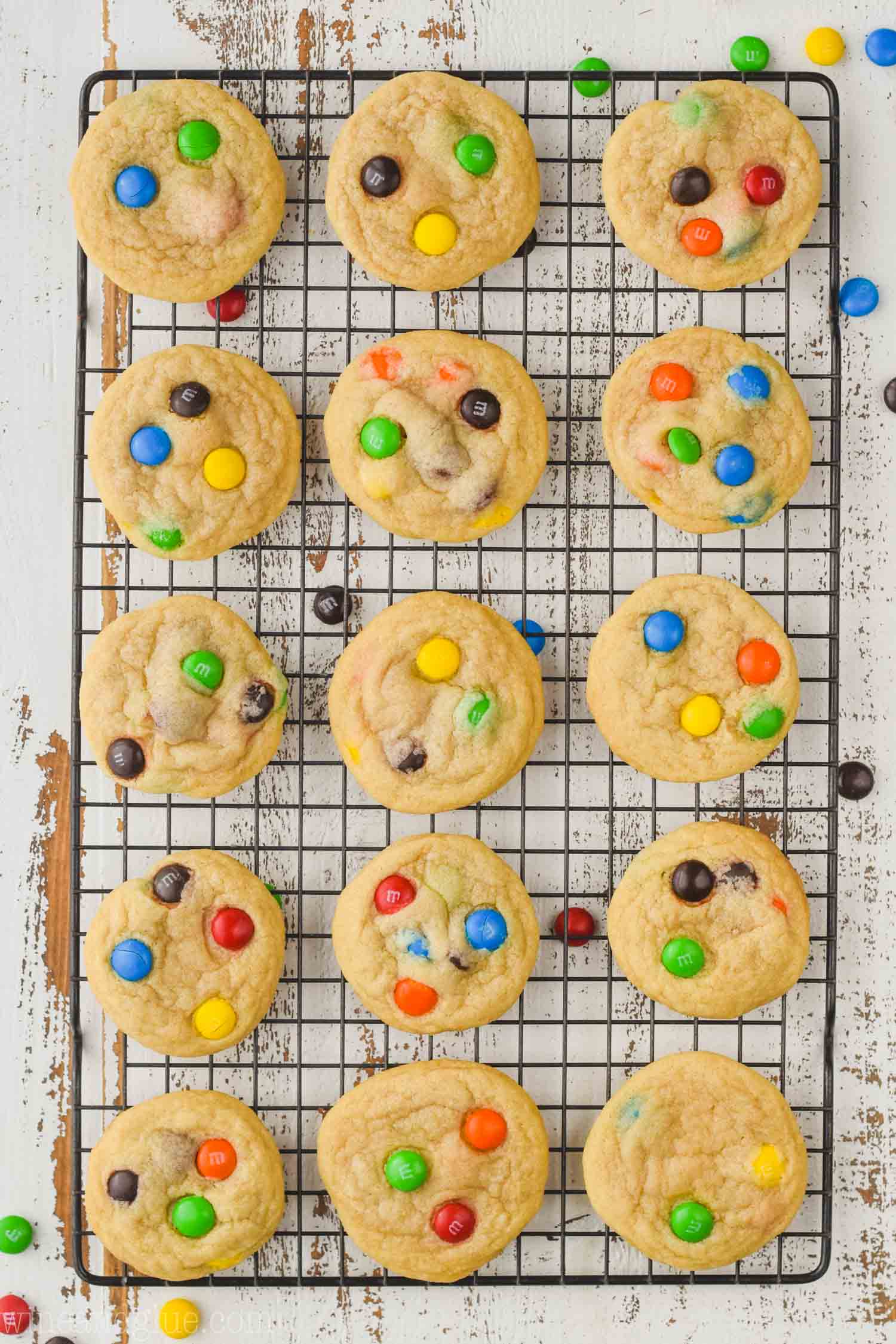 way pulled back overhead photo of a batch of m&m cookies on a wire cooling rack