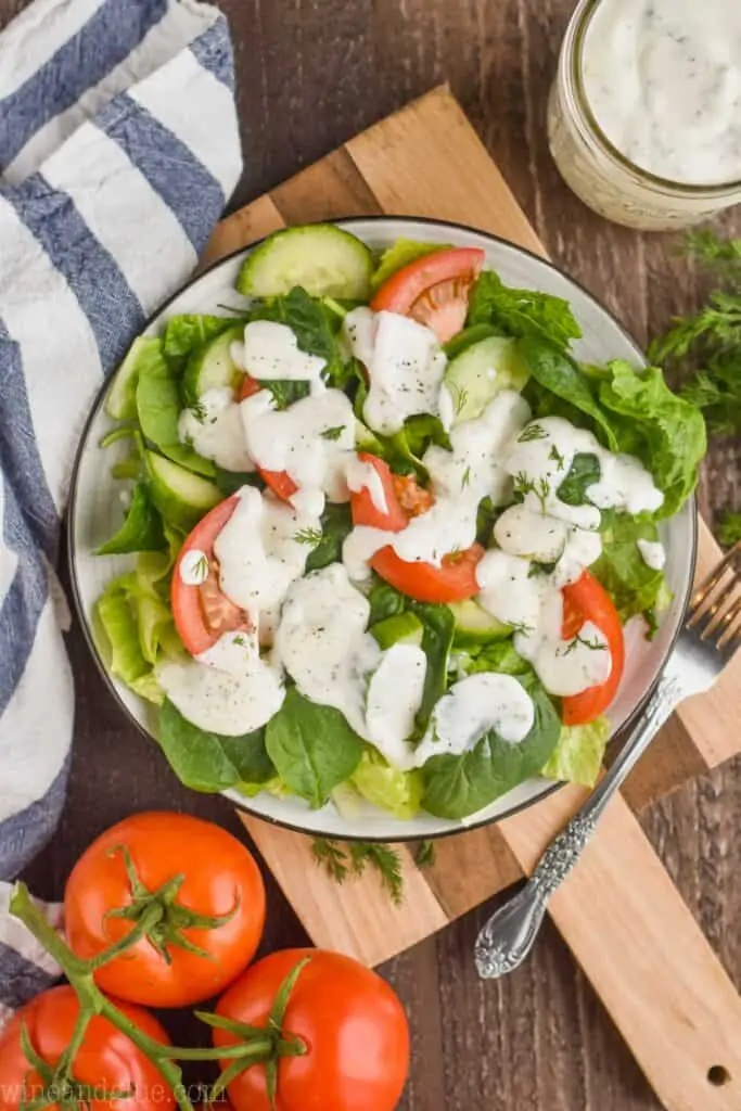 overhead view of a salad on a plate on a cutting board topped with ranch dressing recipe