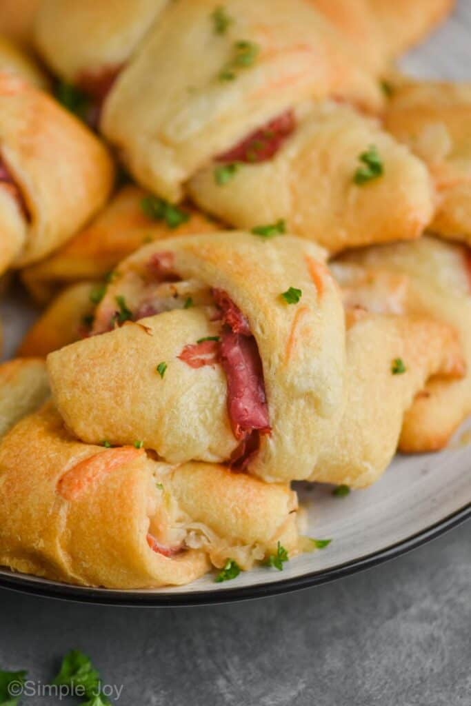 a close up of a reuben crescent roll after being baked on a plate with others