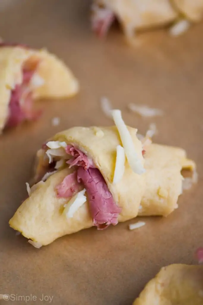 an uncooked reuben crescent roll on close up on a parchment paper