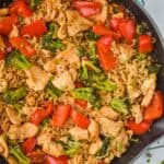 up close overhead view of a stir fry noodle recipe in a teal skillet with ramen noodles, chicken, and vegetables - 9