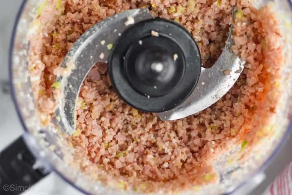 close up overhead of ingredients for ham salad recipe after they have been broken up and processed in food processor