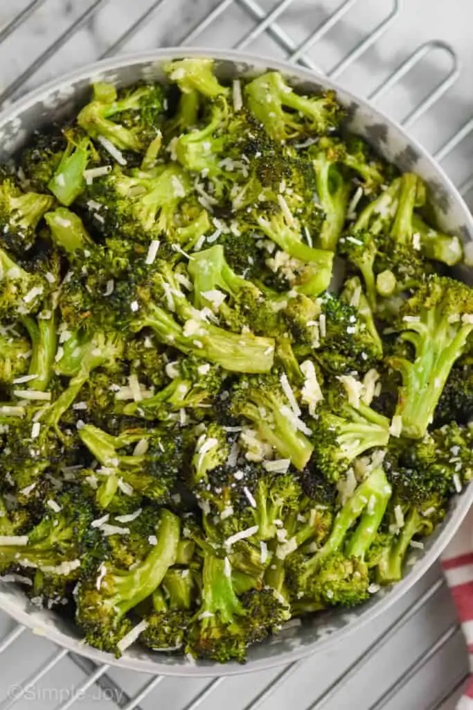 overhead view of parmesan broccoli in a white bowl on a wire rack