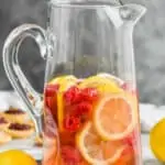 tall pitcher filled with sparkling rose sangria, fresh raspberries, and lemon slices