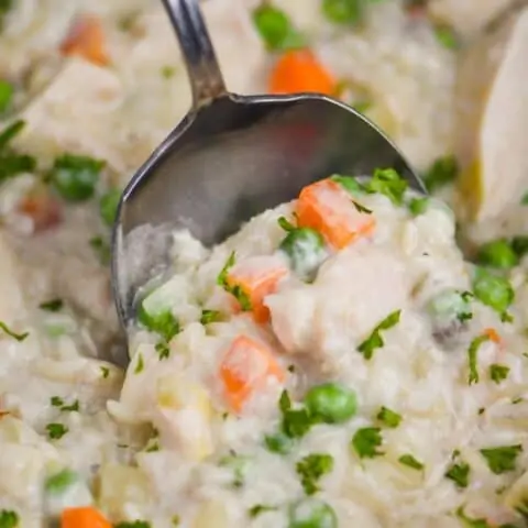 close up of a spoon dishing up slow cooker easy chicken and rice casserole