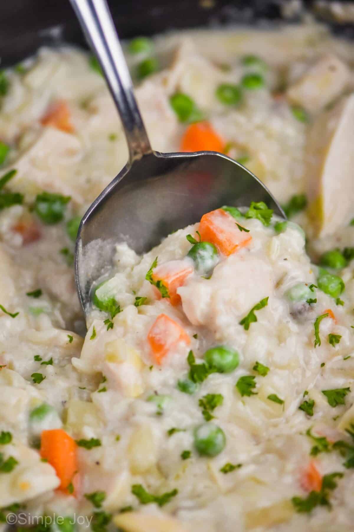 close up of a spoon dishing up slow cooker easy chicken and rice casserole