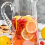 tall pitcher filled with sparkling rose sangria, fresh raspberries, and lemon slices
