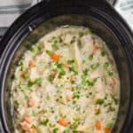 overhead view of a crockpot with chicken and rice casserole garnished with fresh parsley