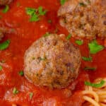 close up of Italian meatball on sauce and spaghetti