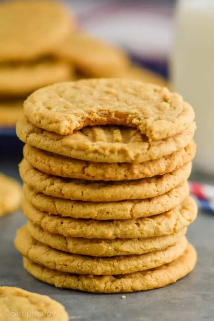 stack of 10 easy peanut butter cookies with the top one having a bite missing