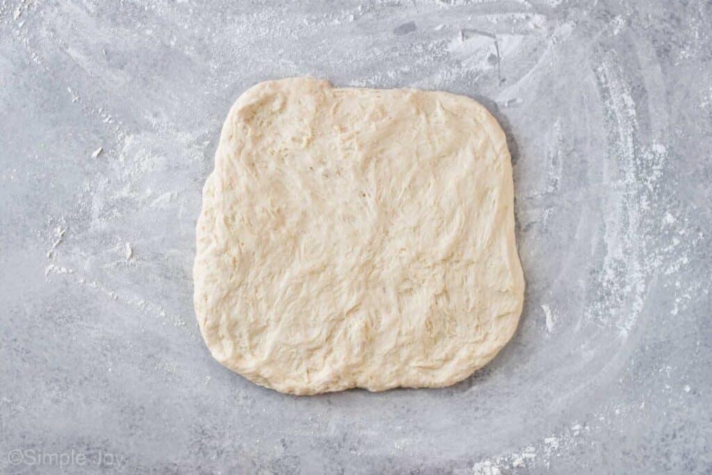 overhead view of bread dough formed into a square
