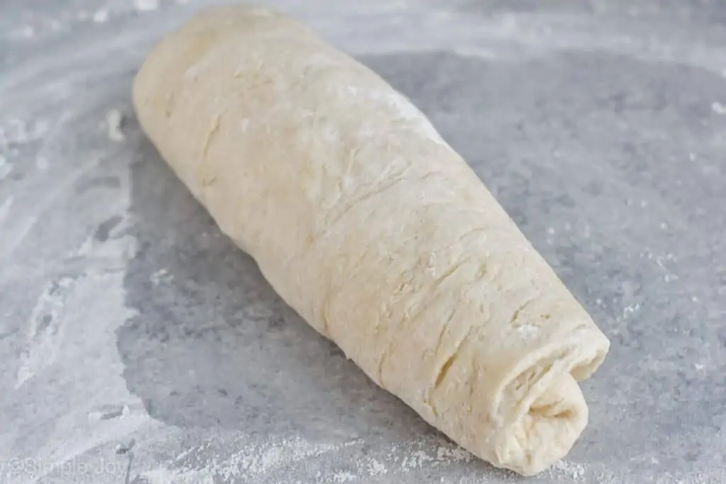 rolled up sandwich bread dough waiting to be put in a bread pan
