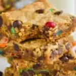 close up of four monster cookie bars with the a bite missing out of the top one
