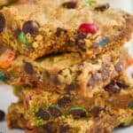 close up of four monster cookie bars with the a bite missing out of the top one - 6