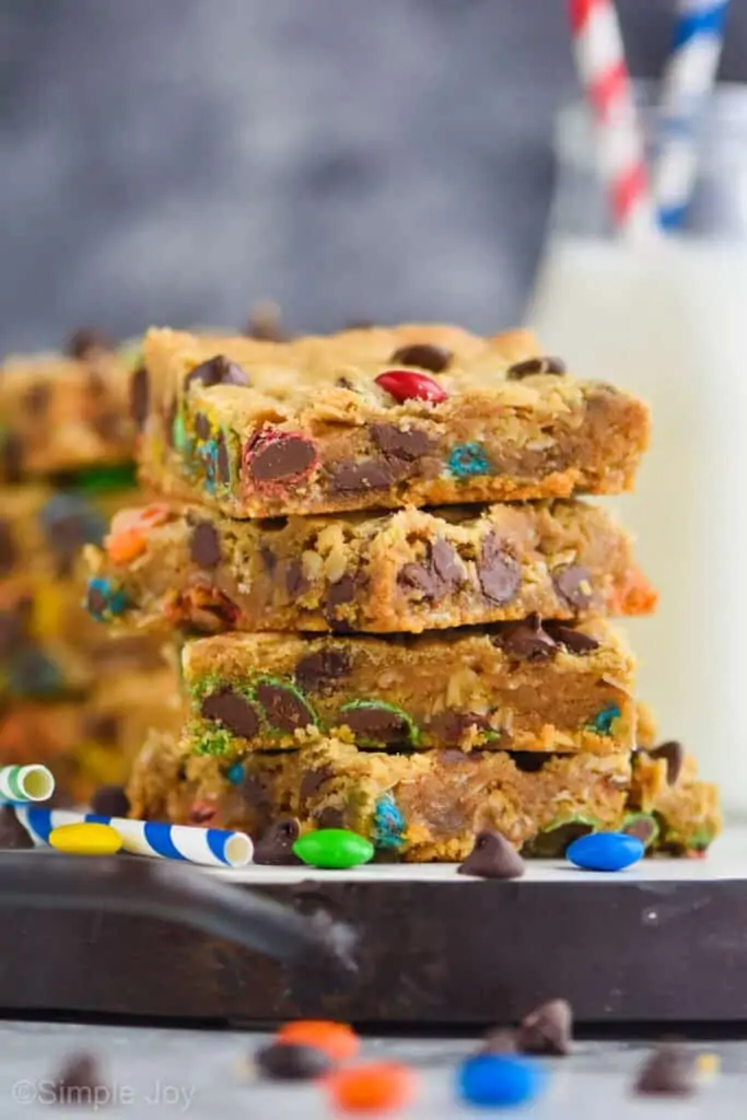 a stack of four monster cookie bar recipe on a black rimmed tray