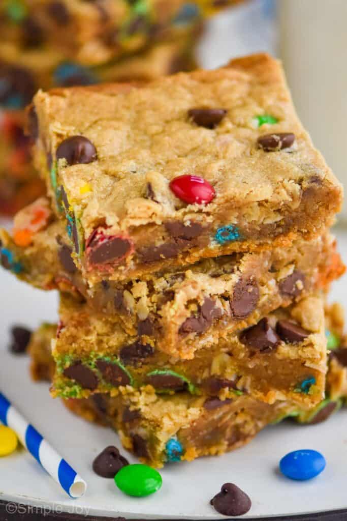 top down look at four monster cookie bars with chocolate chips and M&Ms in them.