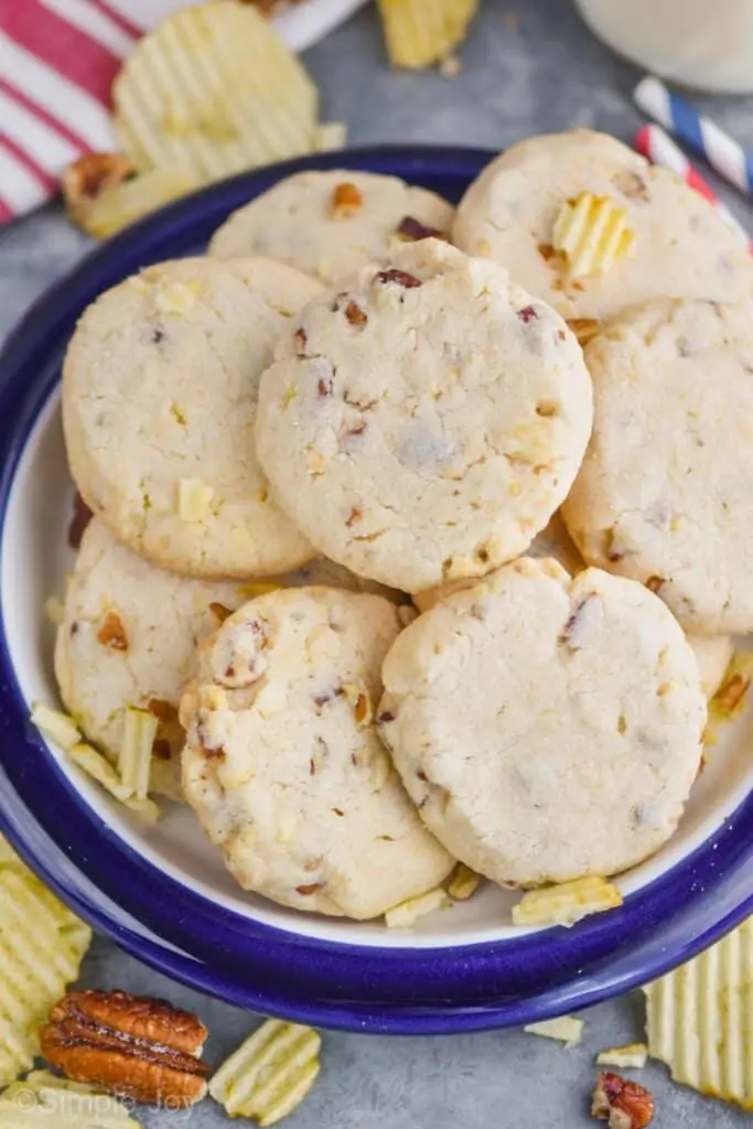 a blue rimmed plate with potato chip and pecan sandies 